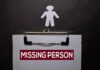 clipboard with missing person notice and paper cutout figure