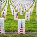 Recruiting Surge Stuns Washington Rows of grave markers adorned with American flags in a military cemetery