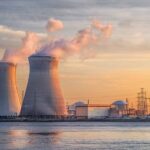 IAEA Alarm: Nuclear Safety Hanging By A Thread Nuclear power plant with cooling towers emitting steam at sunset