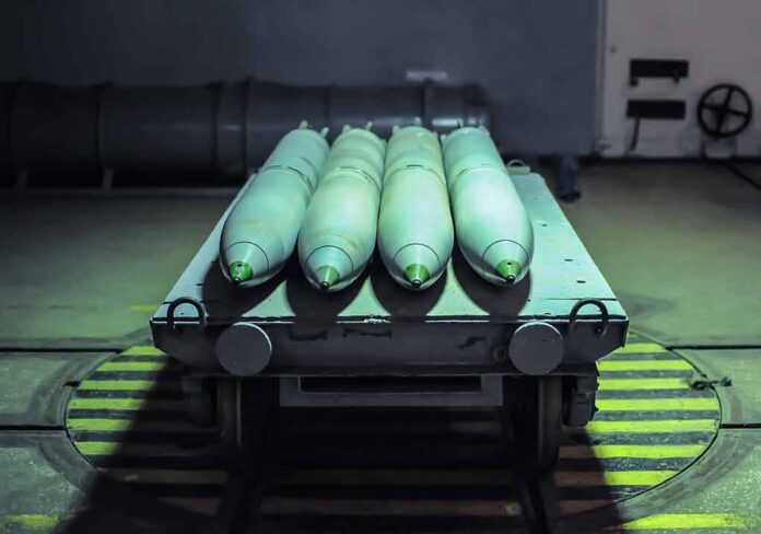 shutterstock_1787893295 Green missiles on a wheeled cart in an industrial bay
