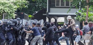 Protesters clash with riot police holding shields