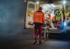 Paramedics load a patient into an ambulance at night