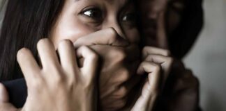woman with hands covering her mouth in fear
