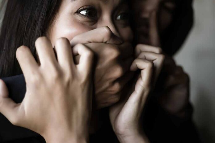 woman with hands covering her mouth in fear