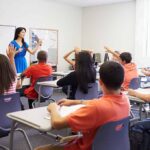 Identity Fight Explodes in Italian Schools Teacher leading classroom discussion with students raising hands