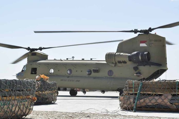 shutterstock_2016442493 Chinook military helicopter on tarmac with cargo pallets