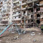 Kyiv Ablaze After Mixed Strikes Damaged apartment building behind a playground slide
