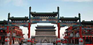 A vibrant traditional Chinese gateway with ornate decorations in an urban setting