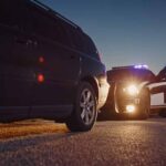 Outrage Erupts After Midnight Pasture Shooting Police officer at patrol car during traffic stop at dusk