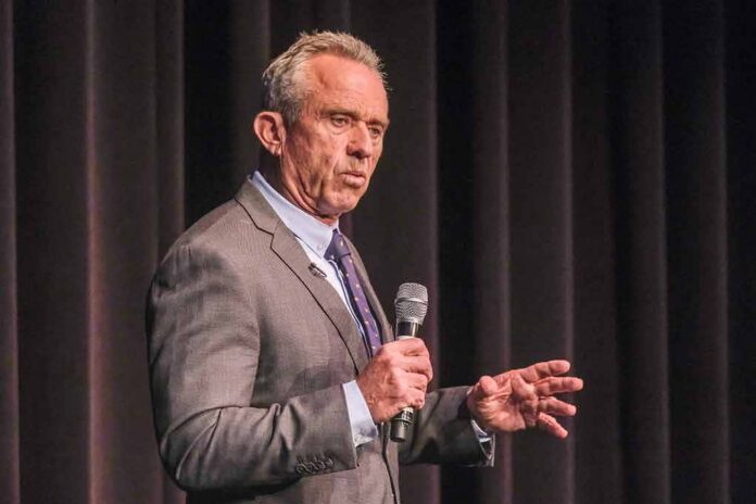 shutterstock_2341983447 man in a suit speaking into a microphone on stage
