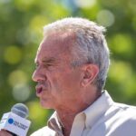 man speaking into a microphone outdoors
