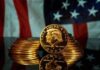 Gold commemorative coins stacked with a profile portrait in front of a U.S. flag