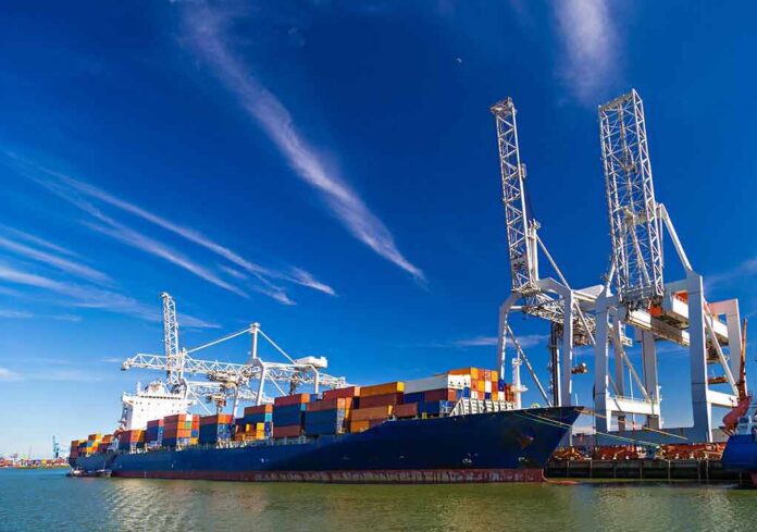 Container ship docked at port with cranes loading cargo