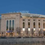 Stadium Shock: Flag Run Stops Subway Series Yankee Stadium exterior at dusk
