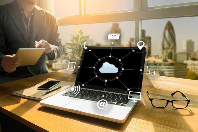 shutterstock_584787934 Laptop on desk showing cloud network icons