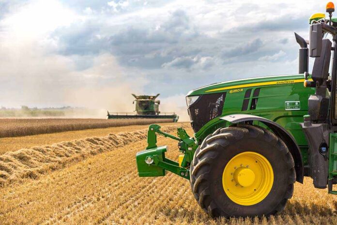 A green tractor in a wheat field.