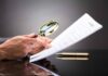 Historic Tradition Test Wrecks Knife Ban Hands holding magnifying glass over contract document