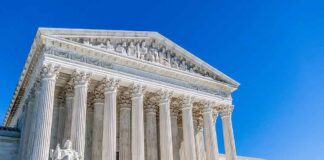 Supreme Court building with tall marble columns under a clear blue sky