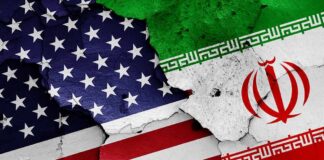United States and Iran flags on cracked wall