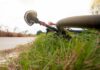 Road bicycle lying on grass beside a rural path