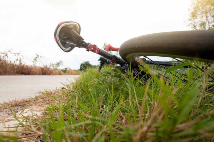 Road bicycle lying on grass beside a rural path