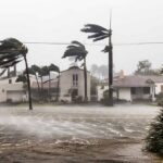 Houses battered by hurricane winds and flooding