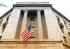 American flag hanging on a neoclassical government building