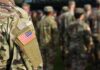 Soldier in camouflage with U.S. flag patch at formation