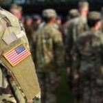 Soldier in camouflage with U.S. flag patch at formation