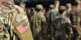Soldier in camouflage with U.S. flag patch at formation