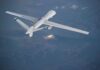 Unmanned aerial drone flying over mountainous terrain