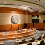 Interior view of a government chamber with wooden paneling and seating