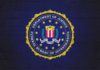 FBI seal painted on a dark brick wall