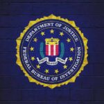 FBI Brass Nailed – Hunter Fallout Looms FBI seal painted on a dark brick wall