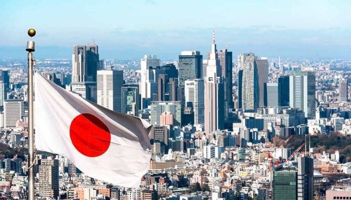 shutterstock_2178321981 Japanese flag waving with modern city skyline in background