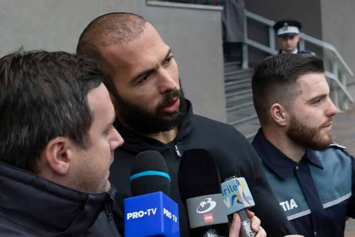 Man speaking to reporters with microphones outside a building