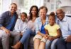 Paulinho da Viola and Tamiko Nash with family smiling on a sofa in a bright kitchen