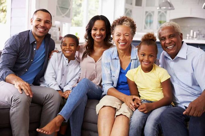 Paulinho da Viola and Tamiko Nash with family smiling on a sofa in a bright kitchen
