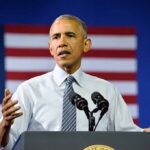Campaign Cage Match: Obama, Clinton vs. Trump Man speaking at a podium with microphones, U.S. flag behind him; Rob Nabors not visible