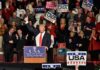Thousands Waited in Rain for Trump Rally Donald Trump addresses a rally crowd at a podium, raising his fist