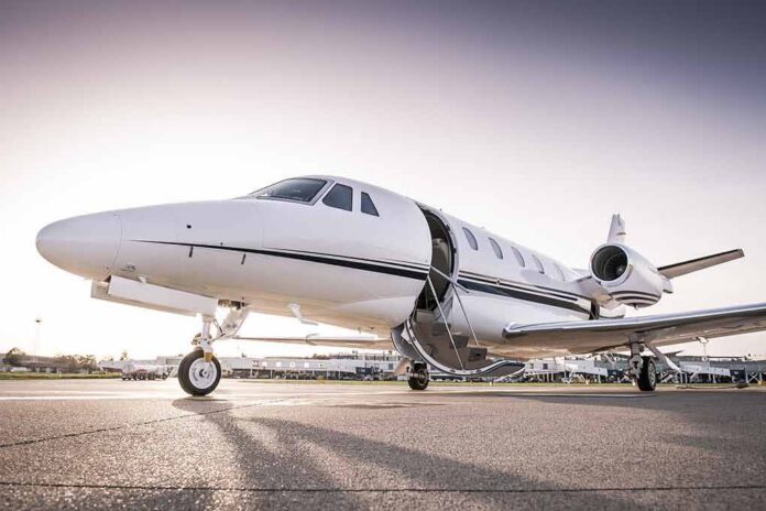 Private jet on airport tarmac with open door at sunset